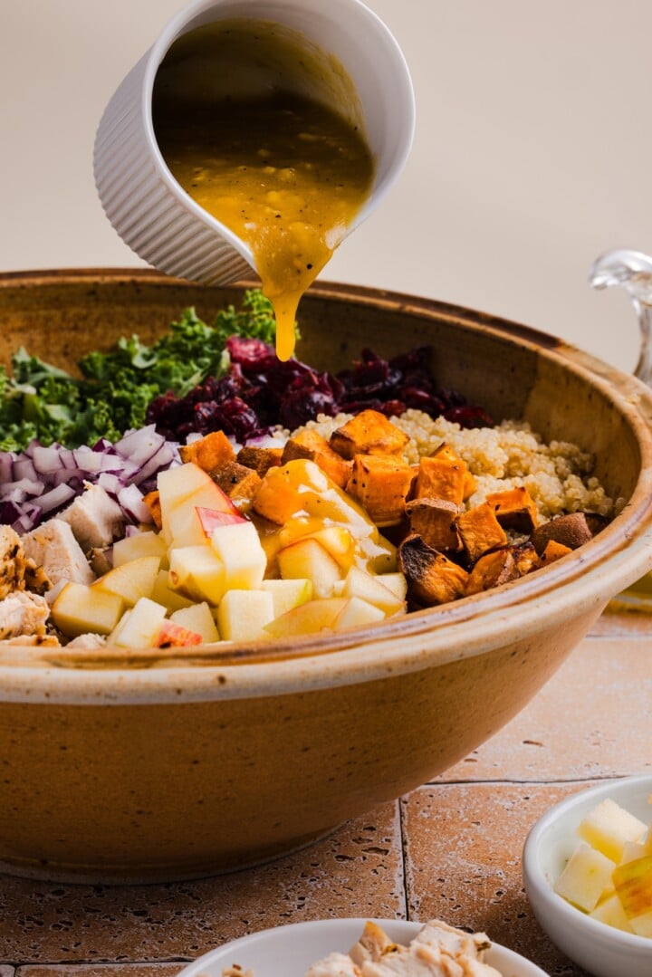 Dressing poured over fall harvest quinoa salad with kale and apple.
