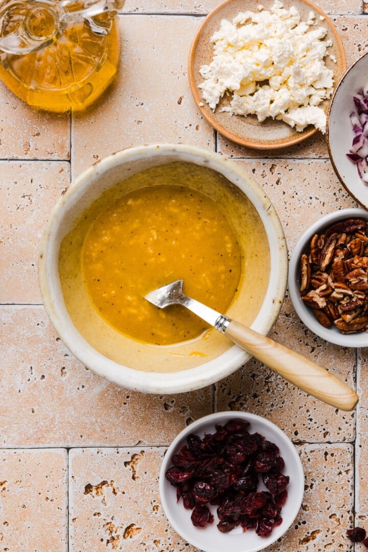 Maple dijon dressing whisked in a small bowl.
