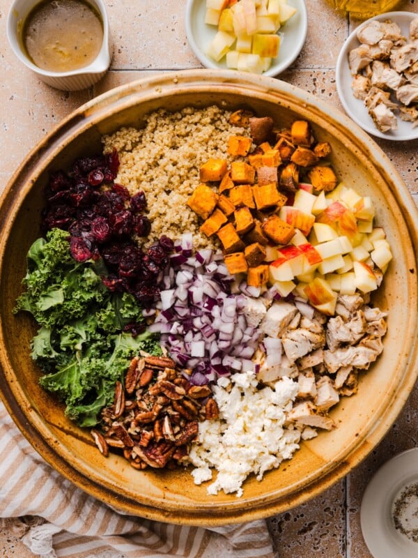 Deconstructed fall harvest quinoa salad in a large wooden mixing bowl.