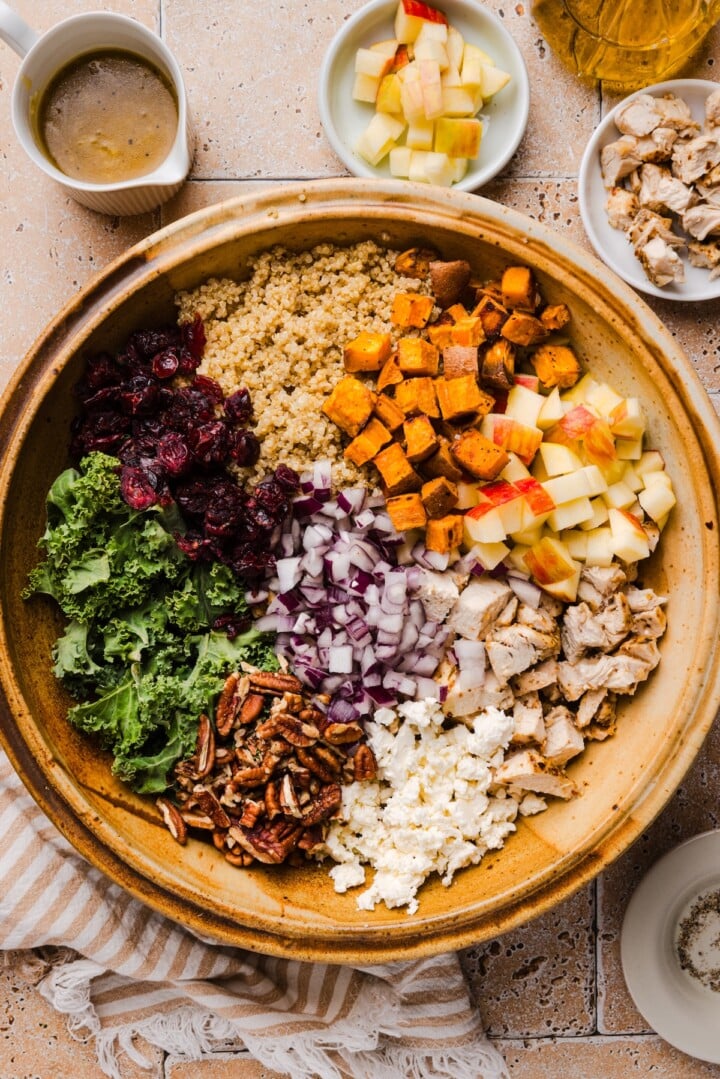 Deconstructed fall harvest quinoa salad in a large wooden mixing bowl.