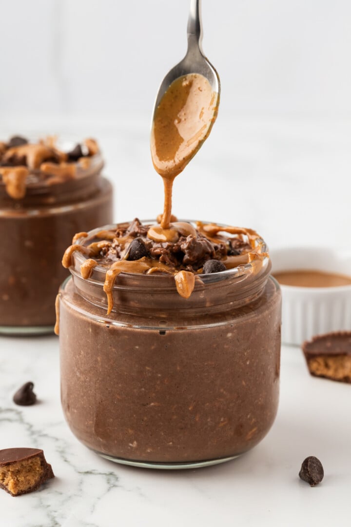 Peanut butter cup overnight oats being drizzled with peanut butter.