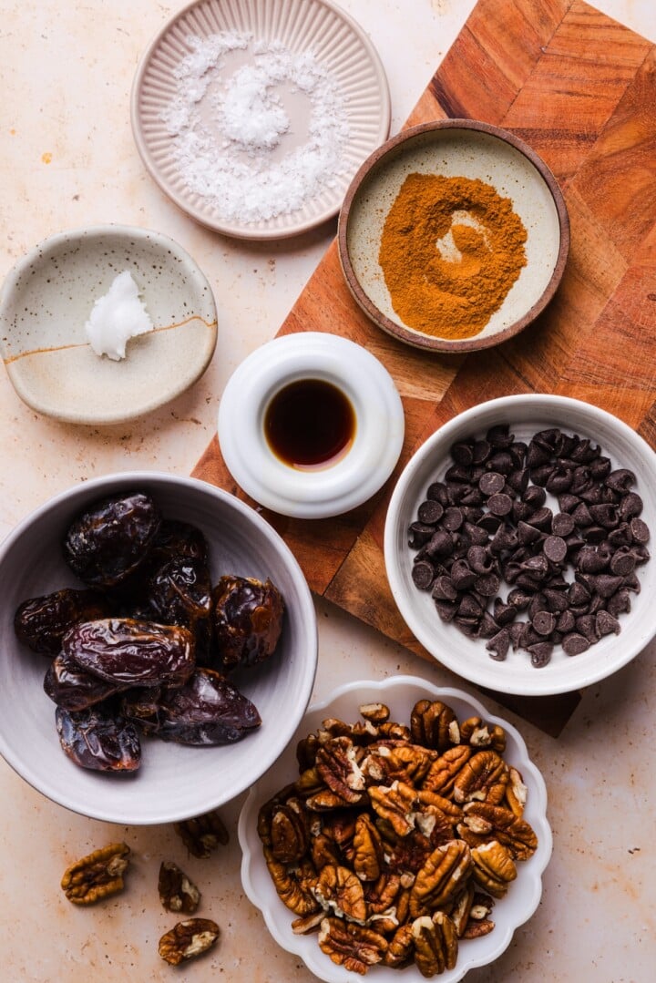 Ingredients for pecan pie energy bites displayed in small bowls.